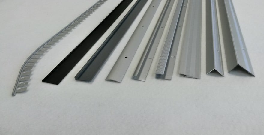 Biegbares Alu-Flex-Profil in Silber eloxiert neben weiteren starren Bodenprofilen in verschiedenen Formen.