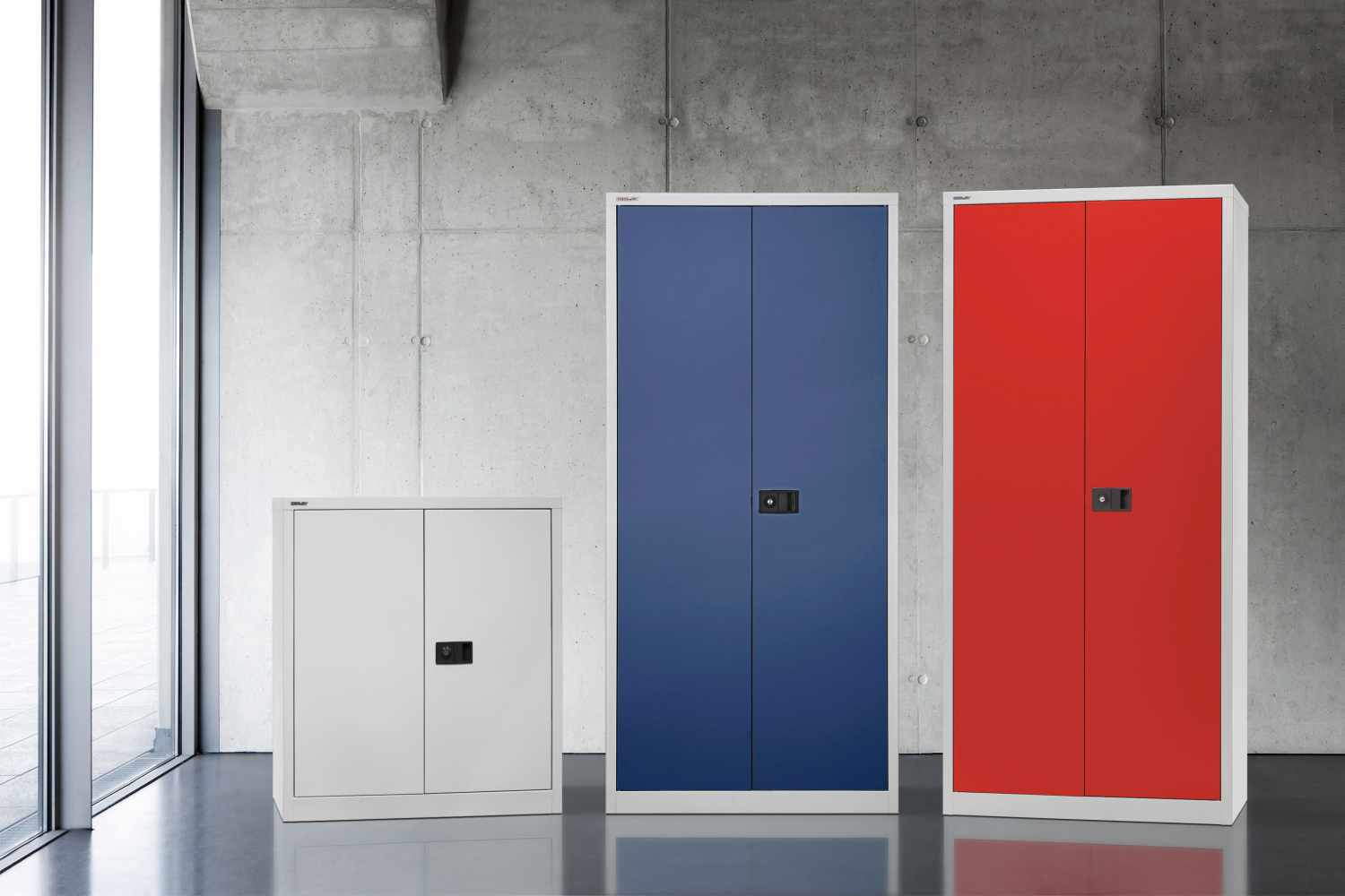 e402a01696_6 Drei Bisley Flügeltürenschränke Universal aus Stahl in Weiß, Blau und Rot in verschiedenen Größen in einem modernen Büro.