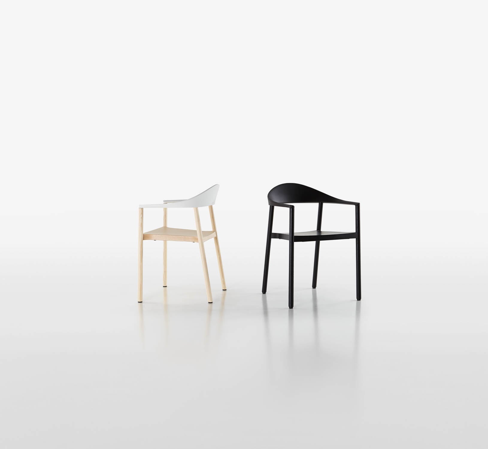 plank_monzaca_groupR53THAUhm12iS Der Monza Armlehnstuhl in zwei Farbvarianten: komplett schwarz und mit weißer Sitzschale auf einem Gestell aus hellem Holz.